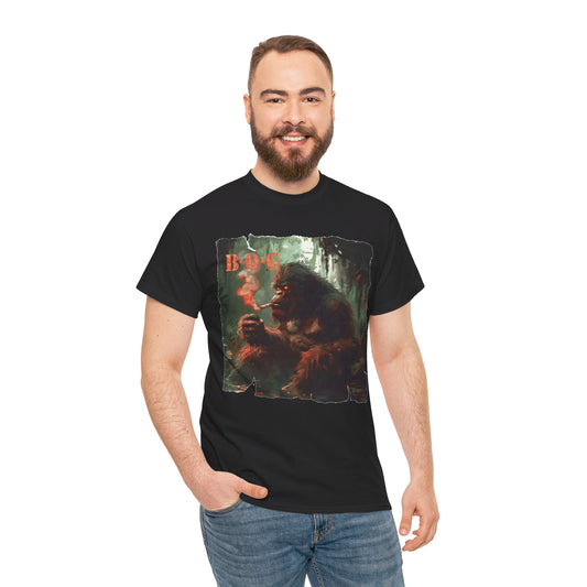 A man waring a black t-shirt with the graphic art of a skunk ape on the front, smoking, in a forest background.
